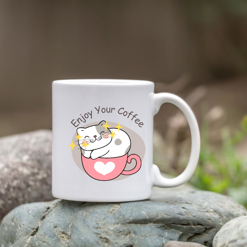 Cute white coffee mug with a smiling cat sitting in a pink heart cup and text Enjoy Your Coffee.