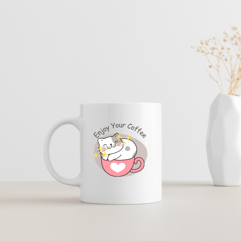 Cute white coffee mug with a smiling cat sitting in a pink heart cup and text Enjoy Your Coffee.